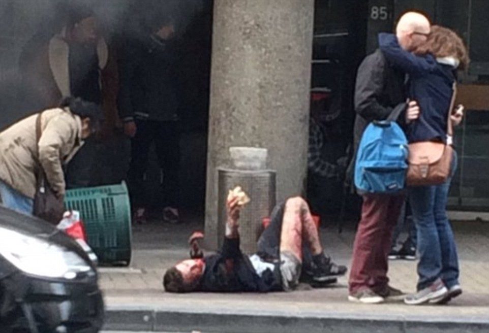 3272CE1300000578-3503928-Aftermath_A_man_lies_stricken_on_the_pavement_as_survivors_kiss_-m-10_1458639898628